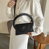 Bolso de hombro de piel de lujo con asa redonda de una marca de alta gama.