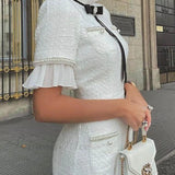 Elegante vestido midi de tweed adornado con perlas y un lazo.