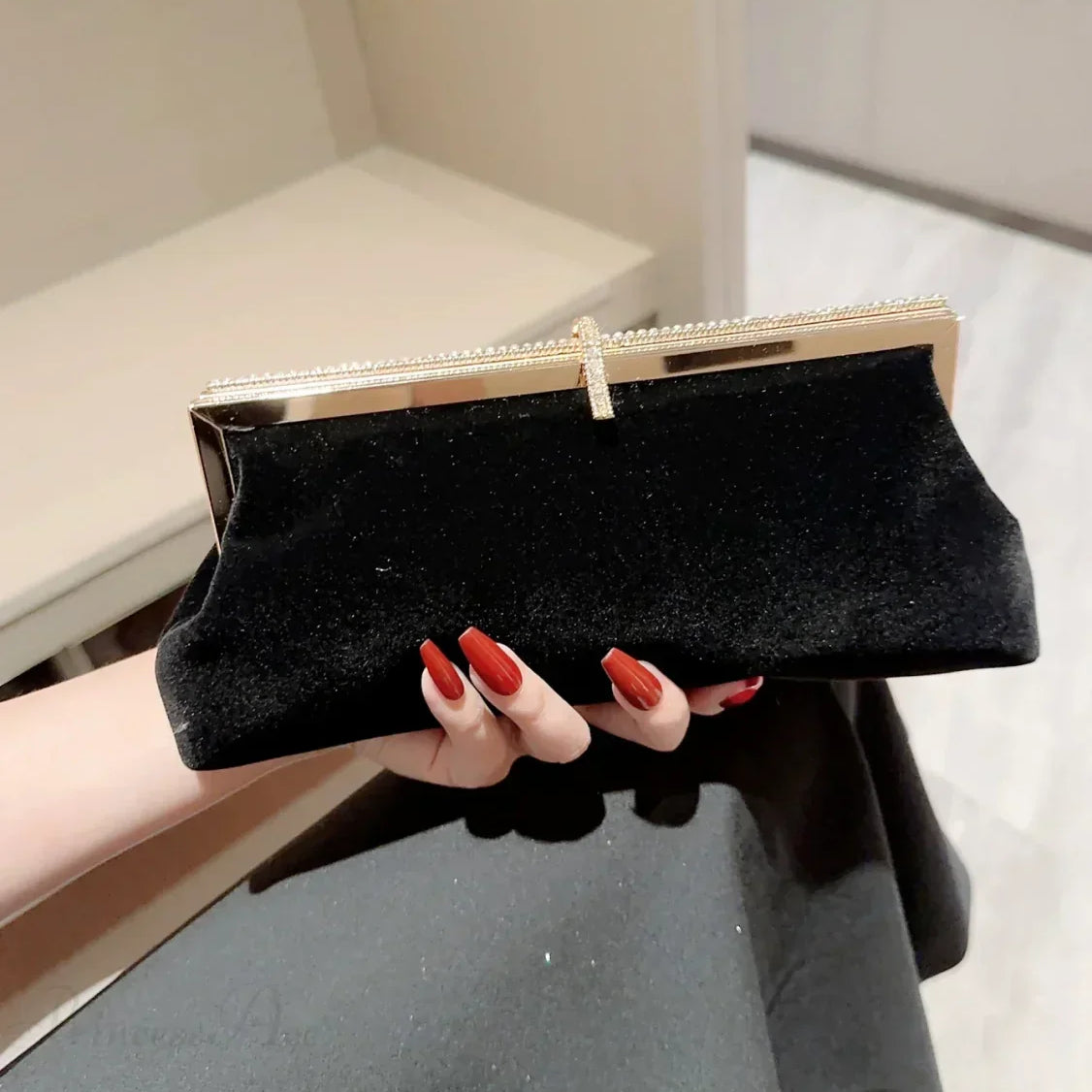 Clutch de noche de terciopelo adornado con pedrería y anzuelos.