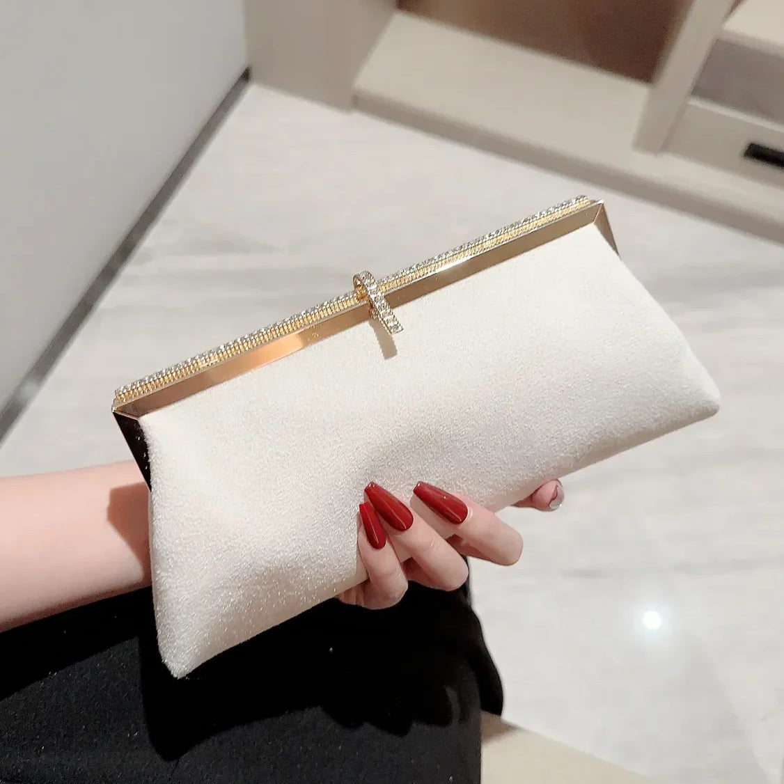Clutch de noche de terciopelo adornado con pedrería y anzuelos.