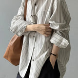 Blusa holgada de algodón con rayas verticales y mangas largas.