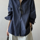 Blusa holgada de algodón con rayas verticales y mangas largas.
