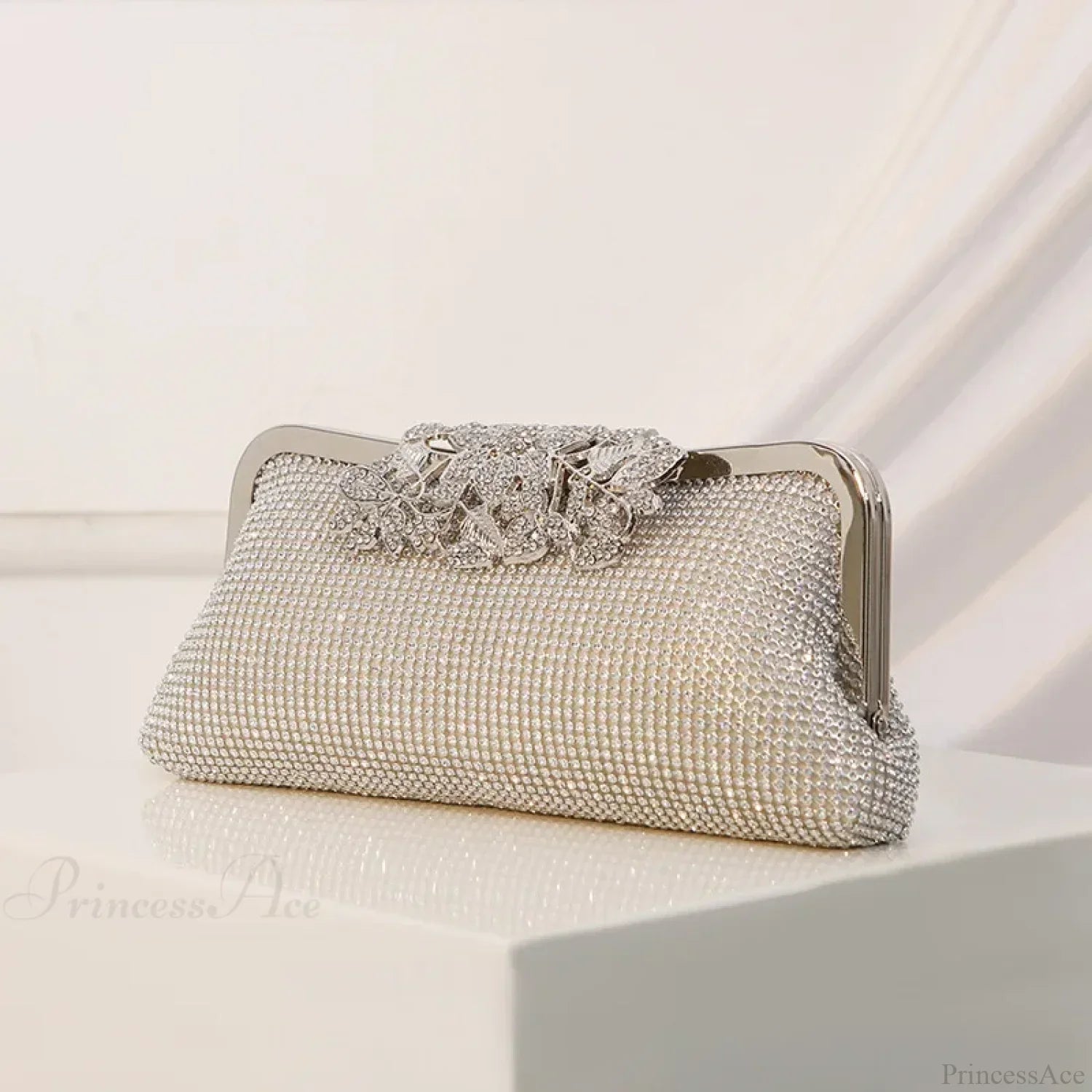 Bolso de mano vintage con cierre de boquilla, adornado con pedrería y flores.
