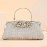Bolso de mano vintage con cierre de boquilla, adornado con pedrería y flores.