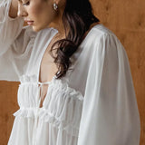 Blusa de gasa blanca con volantes y escote en V con lazo