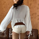 Blusa de gasa blanca con volantes y escote en V con lazo