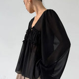 Blusa de gasa blanca con volantes y escote en V con lazo