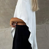 Blusa blanca con cuello redondo asimétrico y mangas cortas.