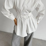 Blusa blanca plisada con cintura ajustada