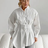 Blusa blanca plisada con cintura ajustada