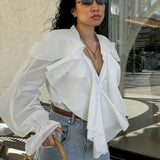 Blusa blanca con volantes, escote en pico y mangas acampanadas