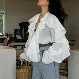 Blusa blanca con volantes, escote en pico y mangas acampanadas