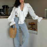 Blusa blanca con volantes, escote en pico y mangas acampanadas